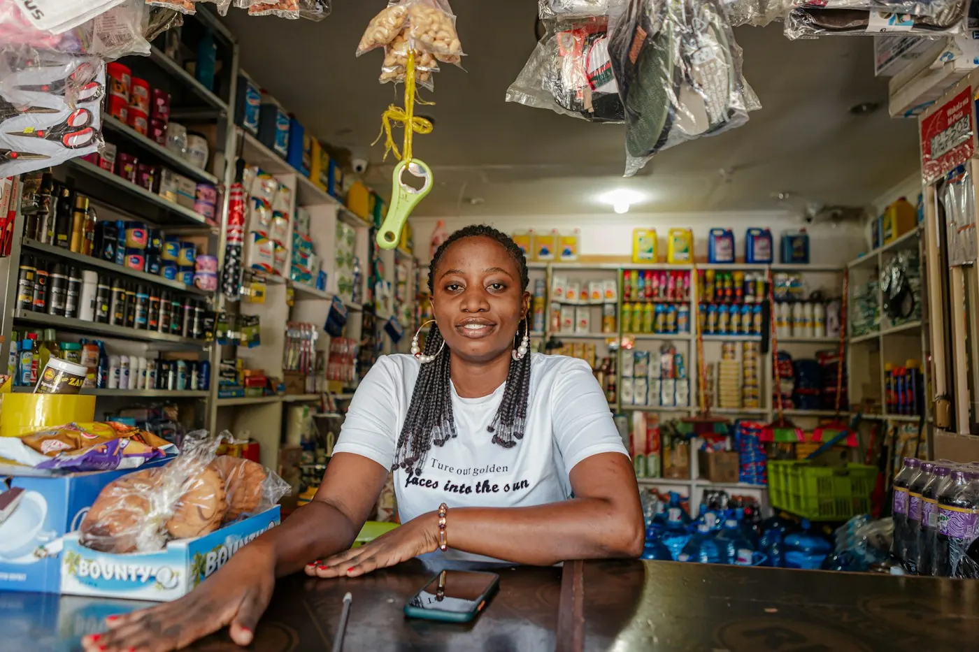A shop owner smiling behind the counter of her small store